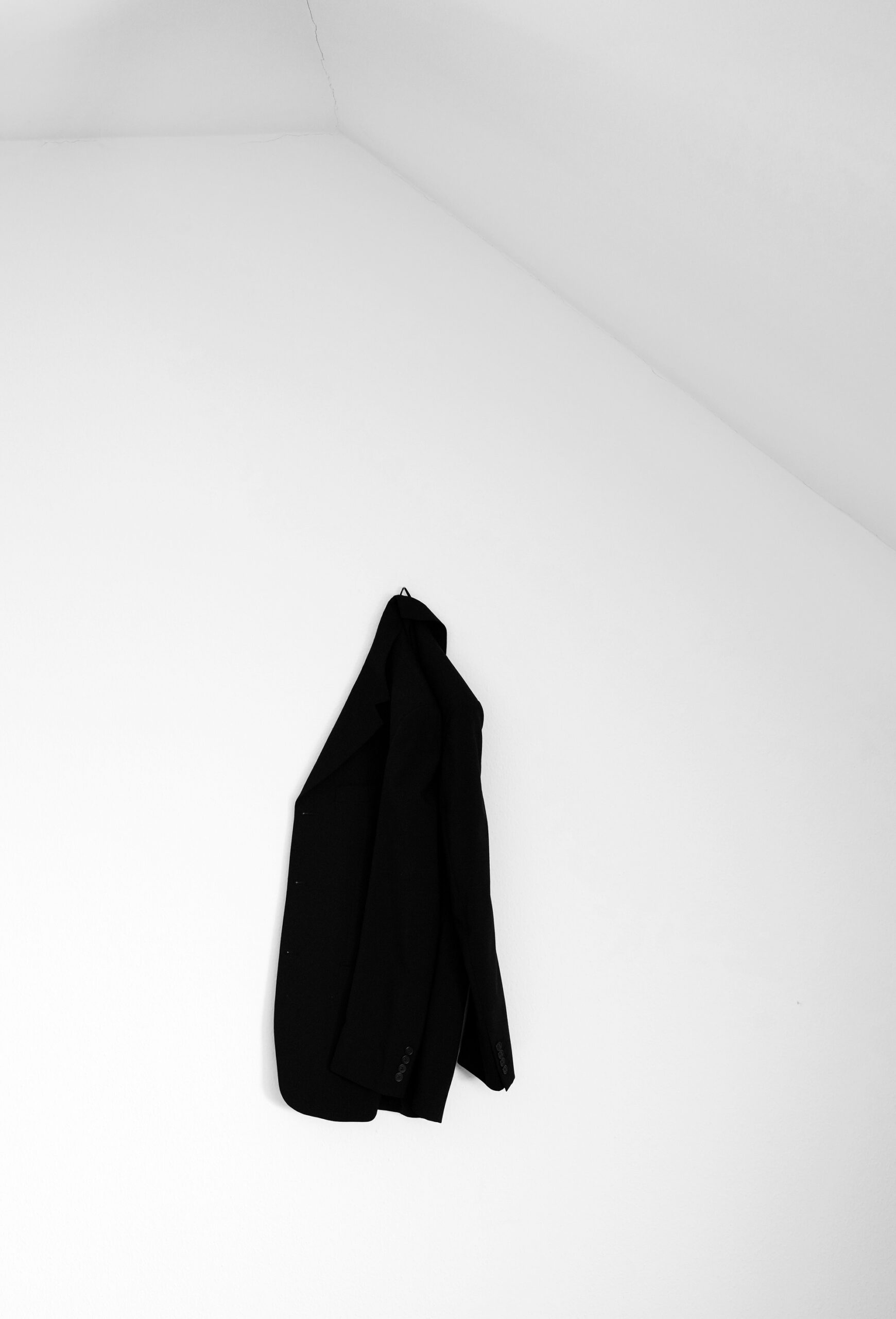 schwarze Jacke vor weißer Wand